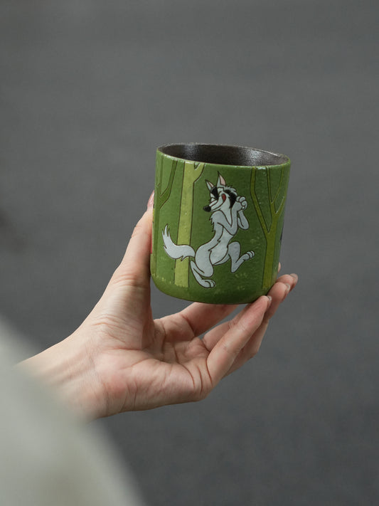 Hand-painted ceramic cup showing the Big Bad Wolf walking through a green forest.