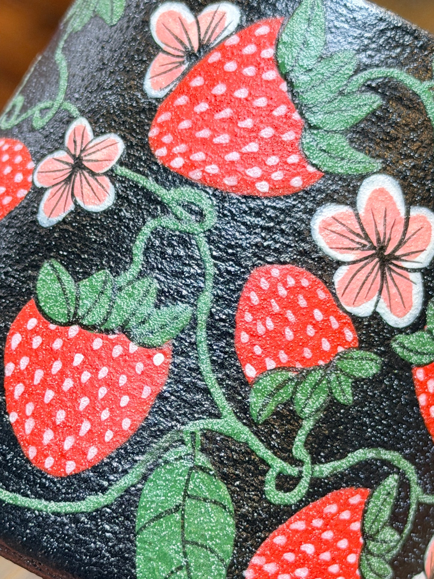 Fabric with strawberry and flower pattern on a black background