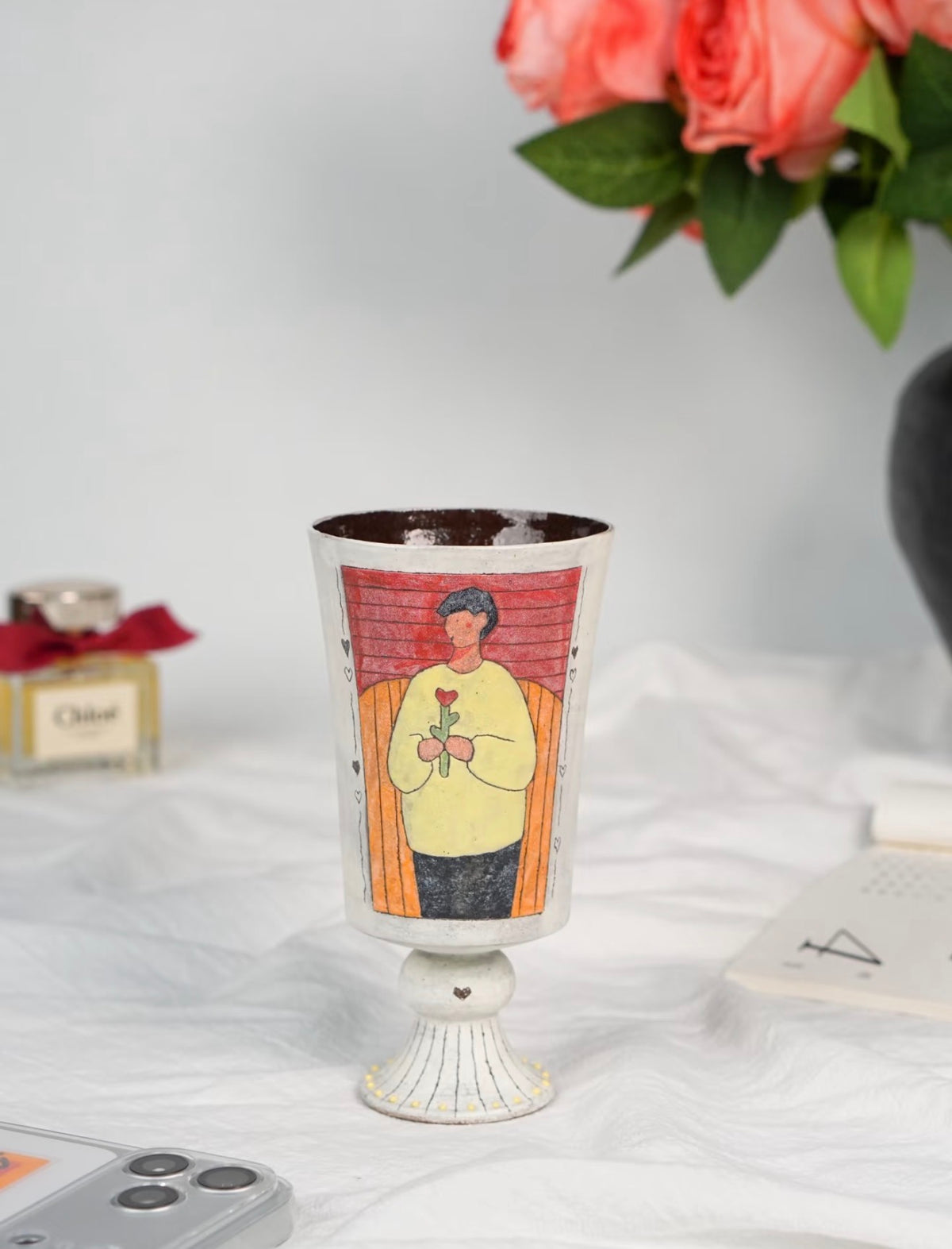 Hand-painted couple pedestal cups displayed together on a soft neutral background.