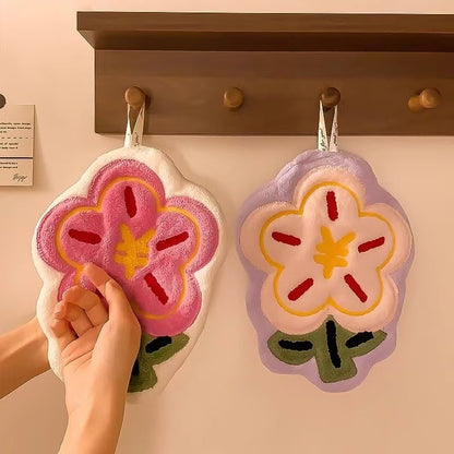 Flower Hand Towel-Floral-patterned bath towels hanging on a rack with a hand holding one towel.
