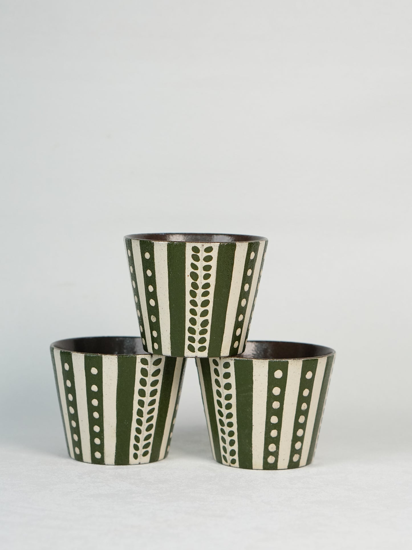 Two green and white patterned bracelets on a light gray background