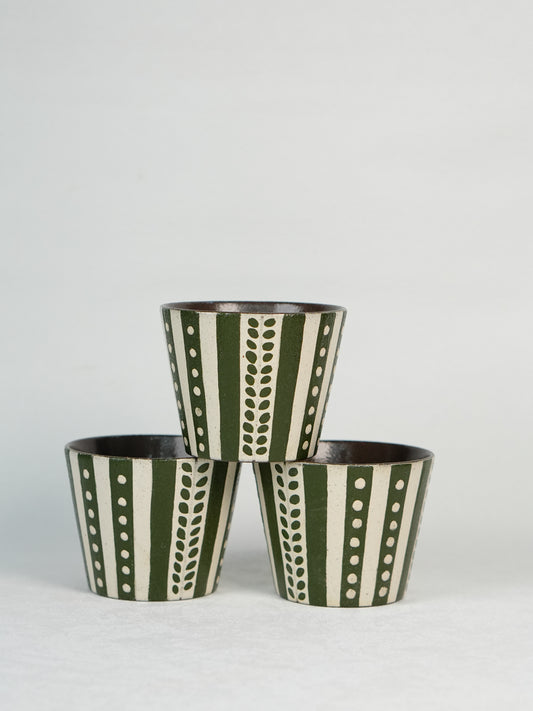 Two green and white patterned bracelets on a light gray background