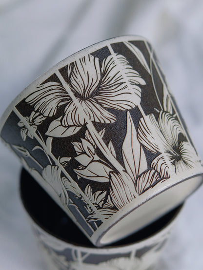 Close-up of hand-carved floral details on a sgraffito ceramic cup