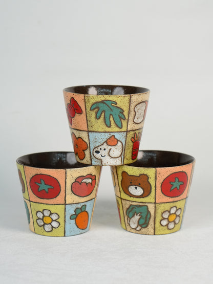 Three colourful garden patchwork ceramic cups displayed together.