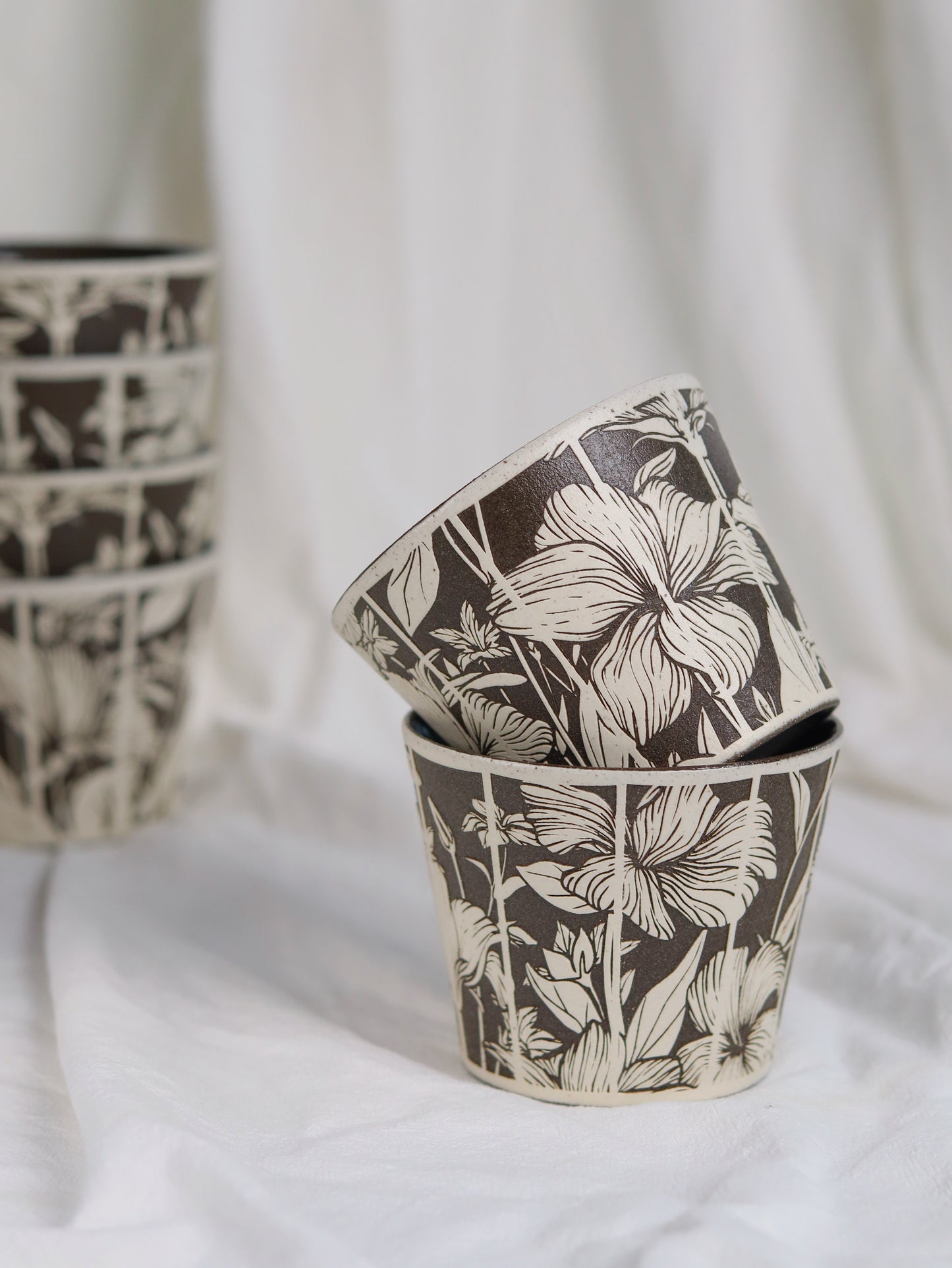 Two botanical sgraffito ceramic cups with hand-carved floral designs