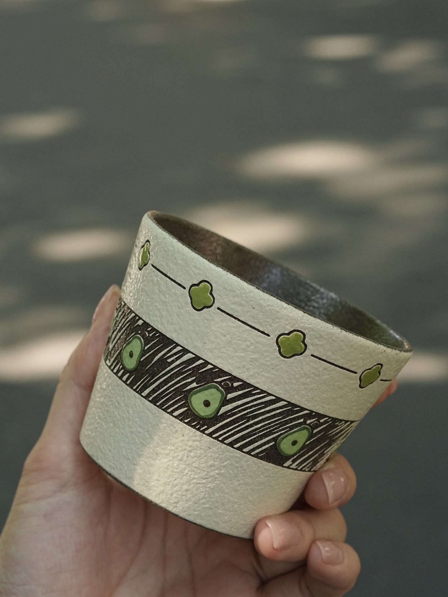 Hand-painted green ceramic cup with avocado pattern and textured finish