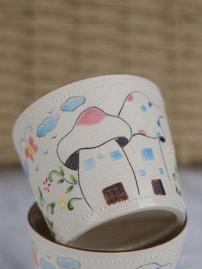 Ceramic mug with a colorful house illustration on a neutral background