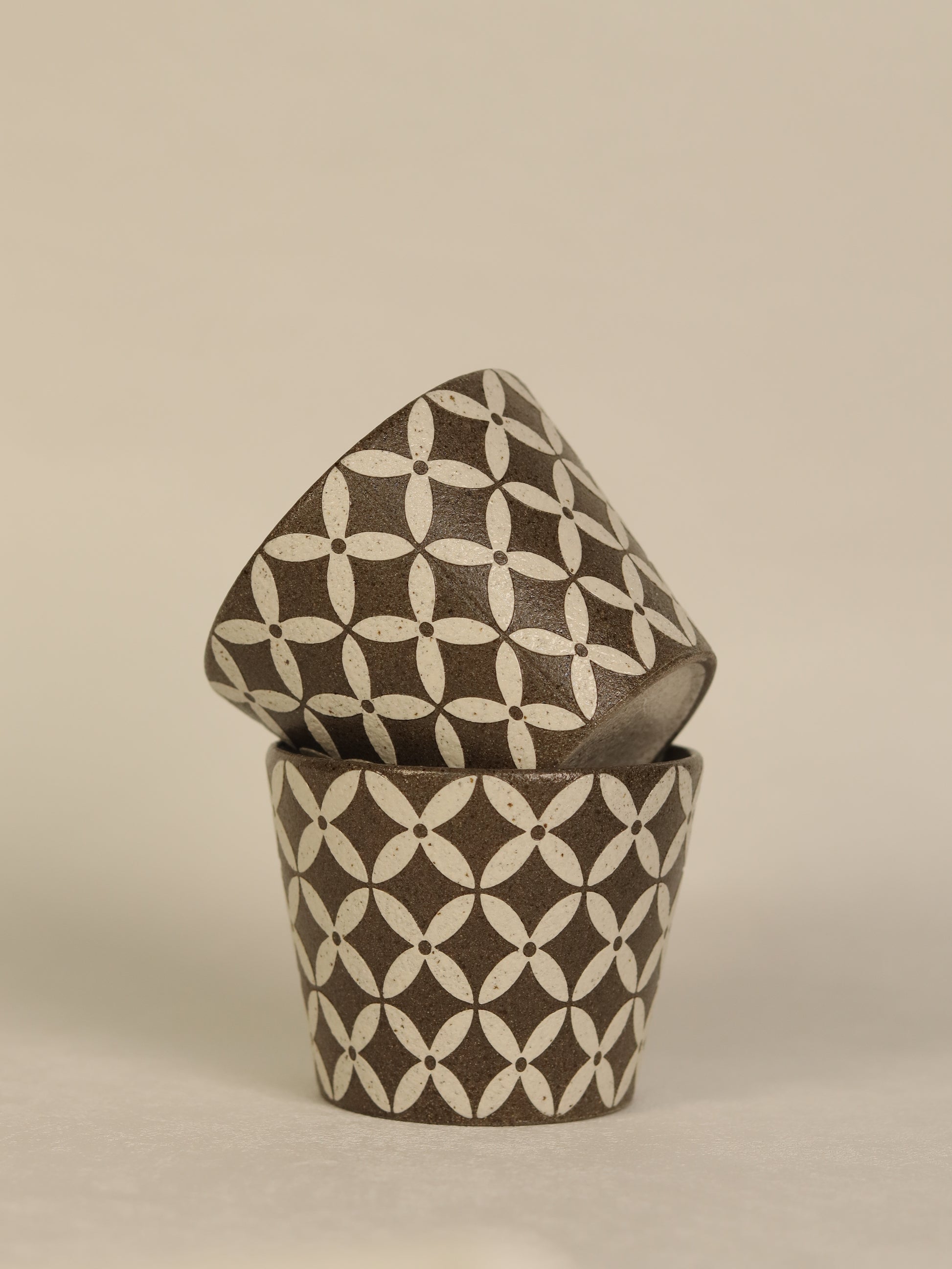 Ceramic container with geometric pattern on a beige background