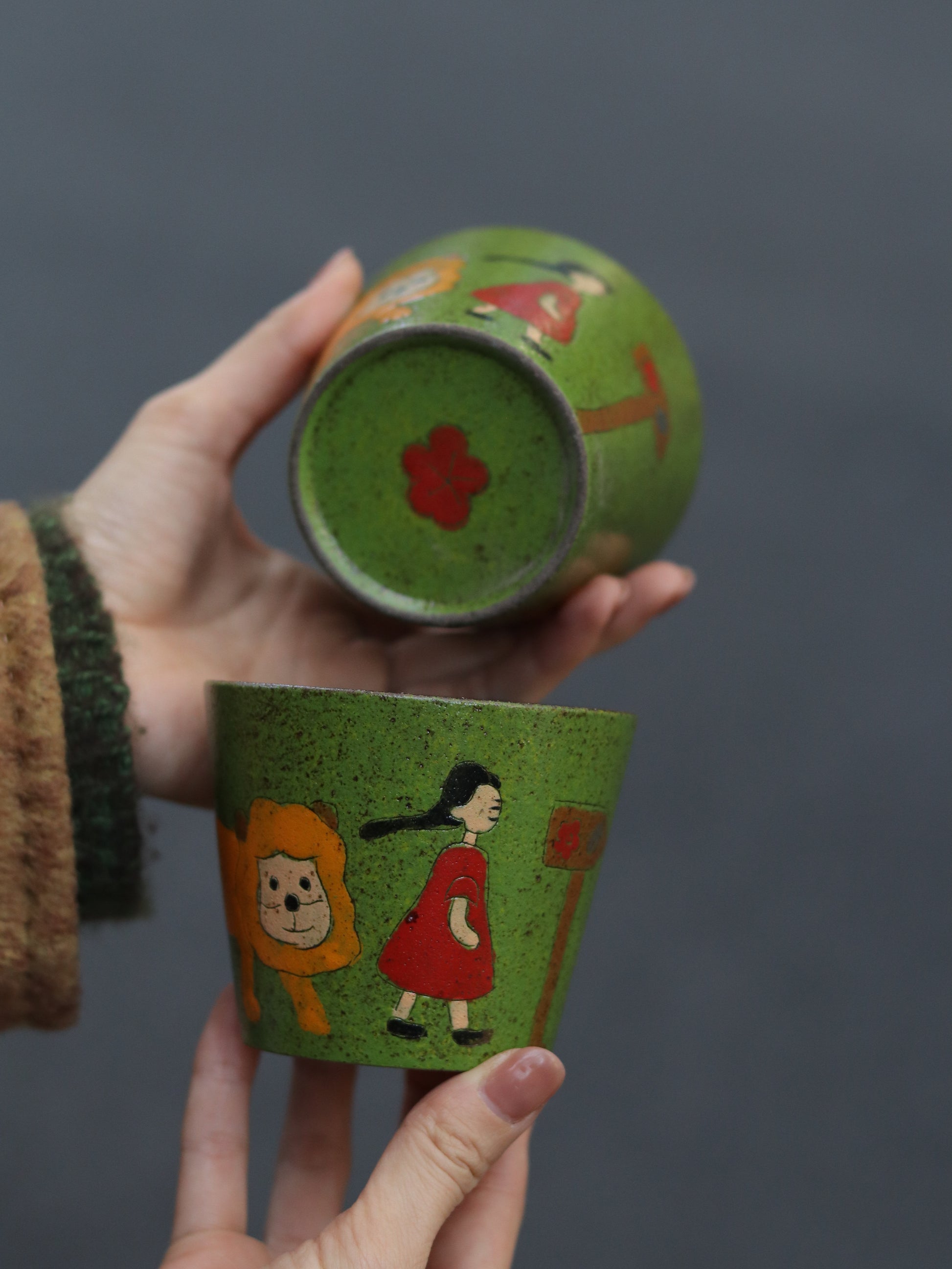 Top and base details of the hand-painted green ceramic cup