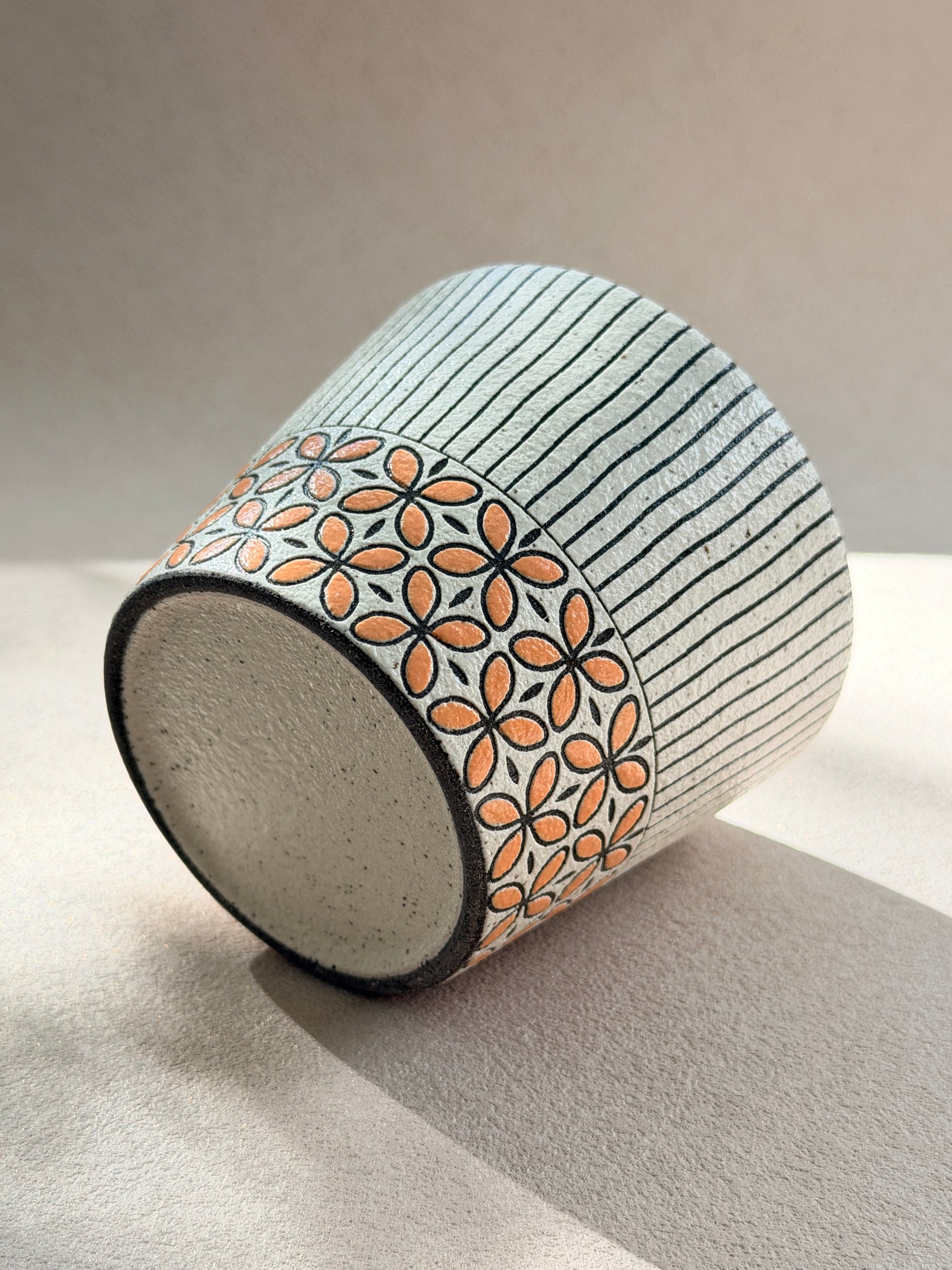 Hand-carved 270ml ceramic cup with orange floral band and fine black vertical stripes