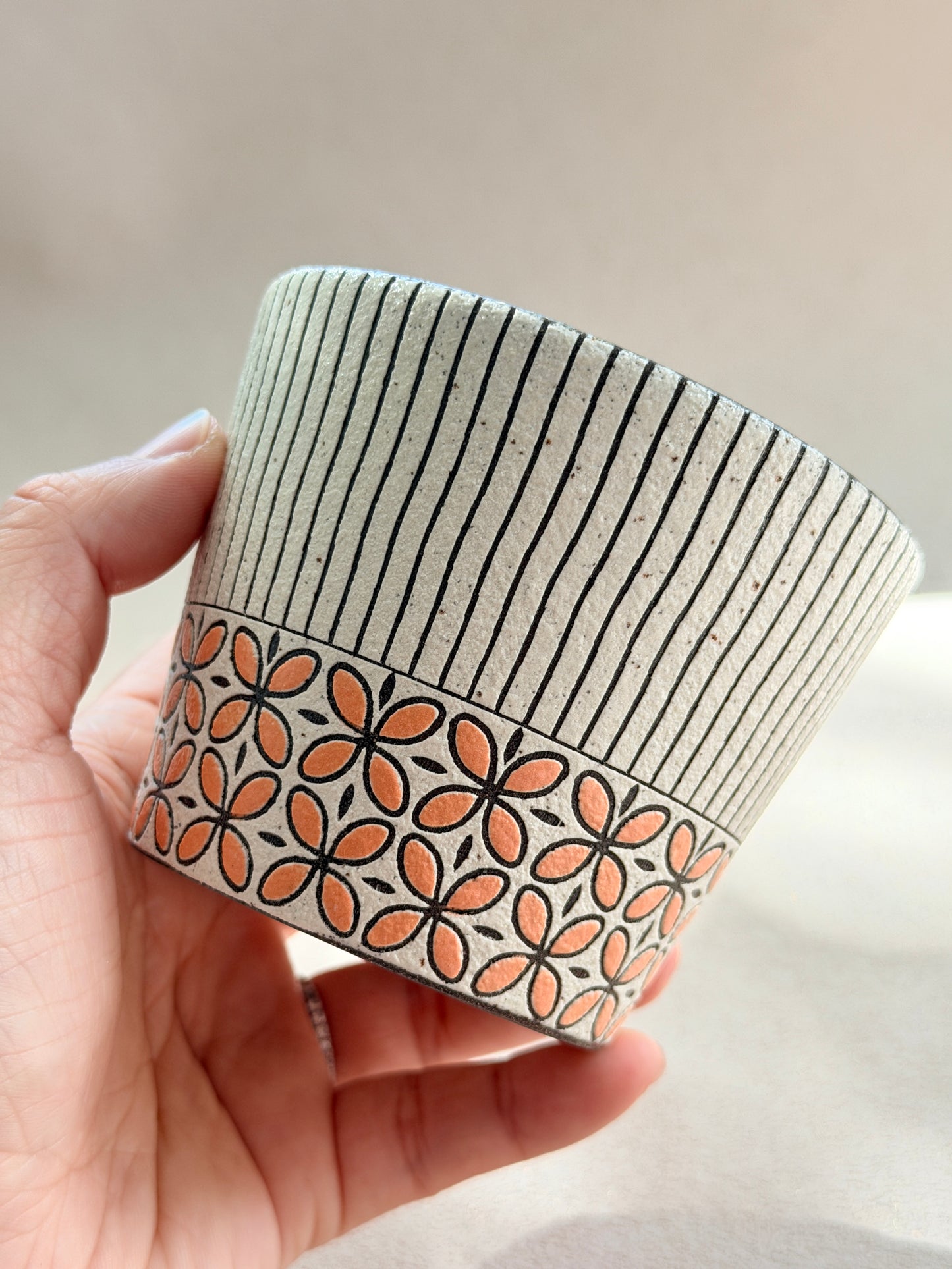 Hand-carved 270ml ceramic cup with orange floral band and fine black vertical stripes