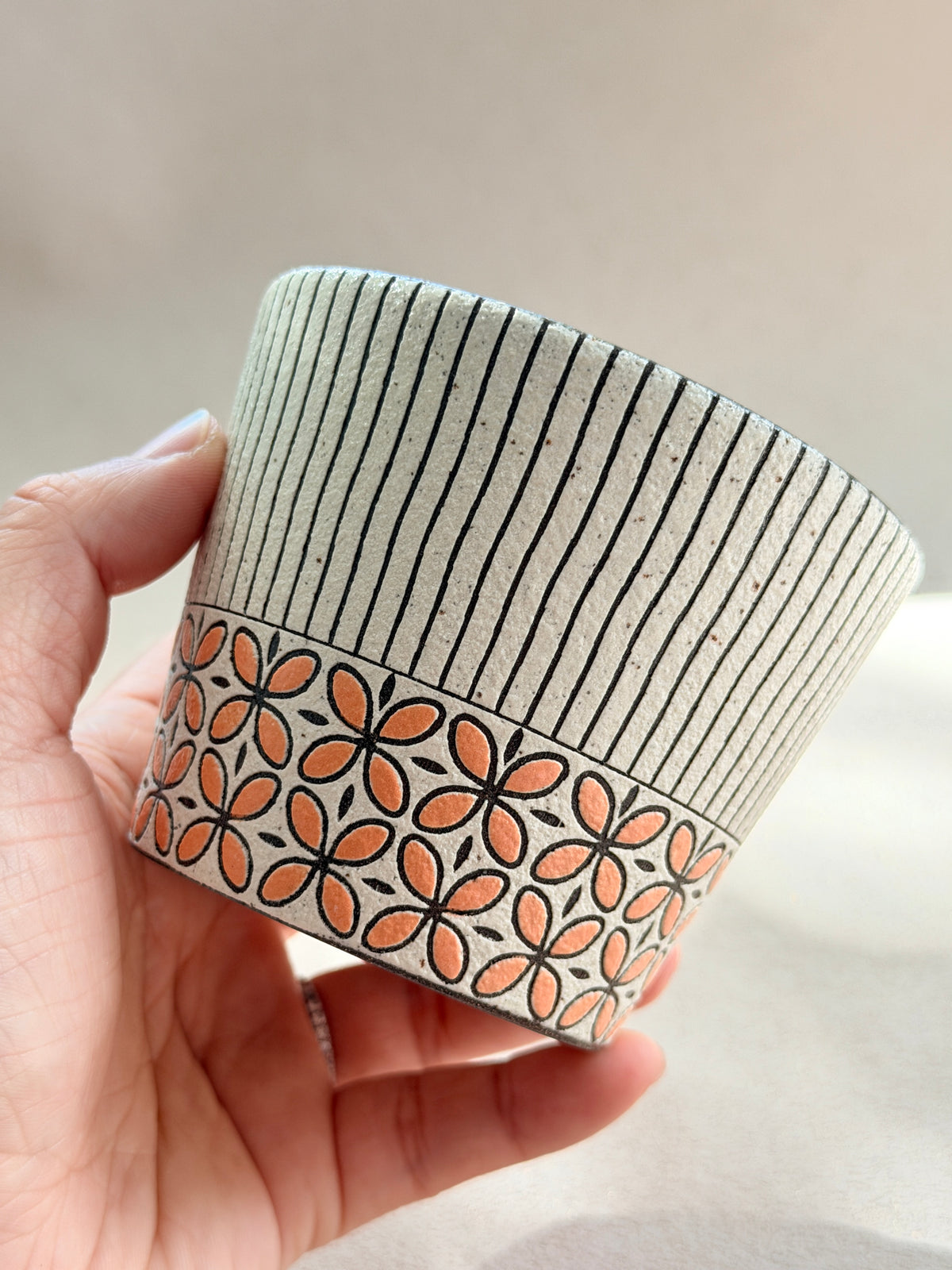 Hand-carved 270ml ceramic cup with orange floral band and fine black vertical stripes