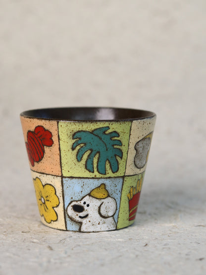 Hand-painted garden patchwork ceramic cup featuring colourful fruit, flowers, leaves and a playful dog.