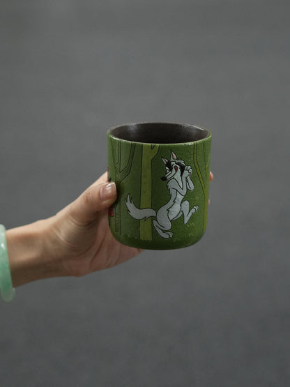 Hand-painted ceramic cup showing the Big Bad Wolf walking through a green forest.