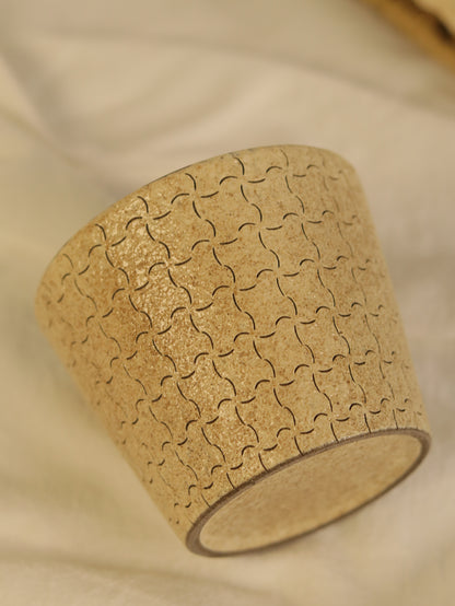 Close-up of a ceramic cup showing the repeating hand-carved line pattern.