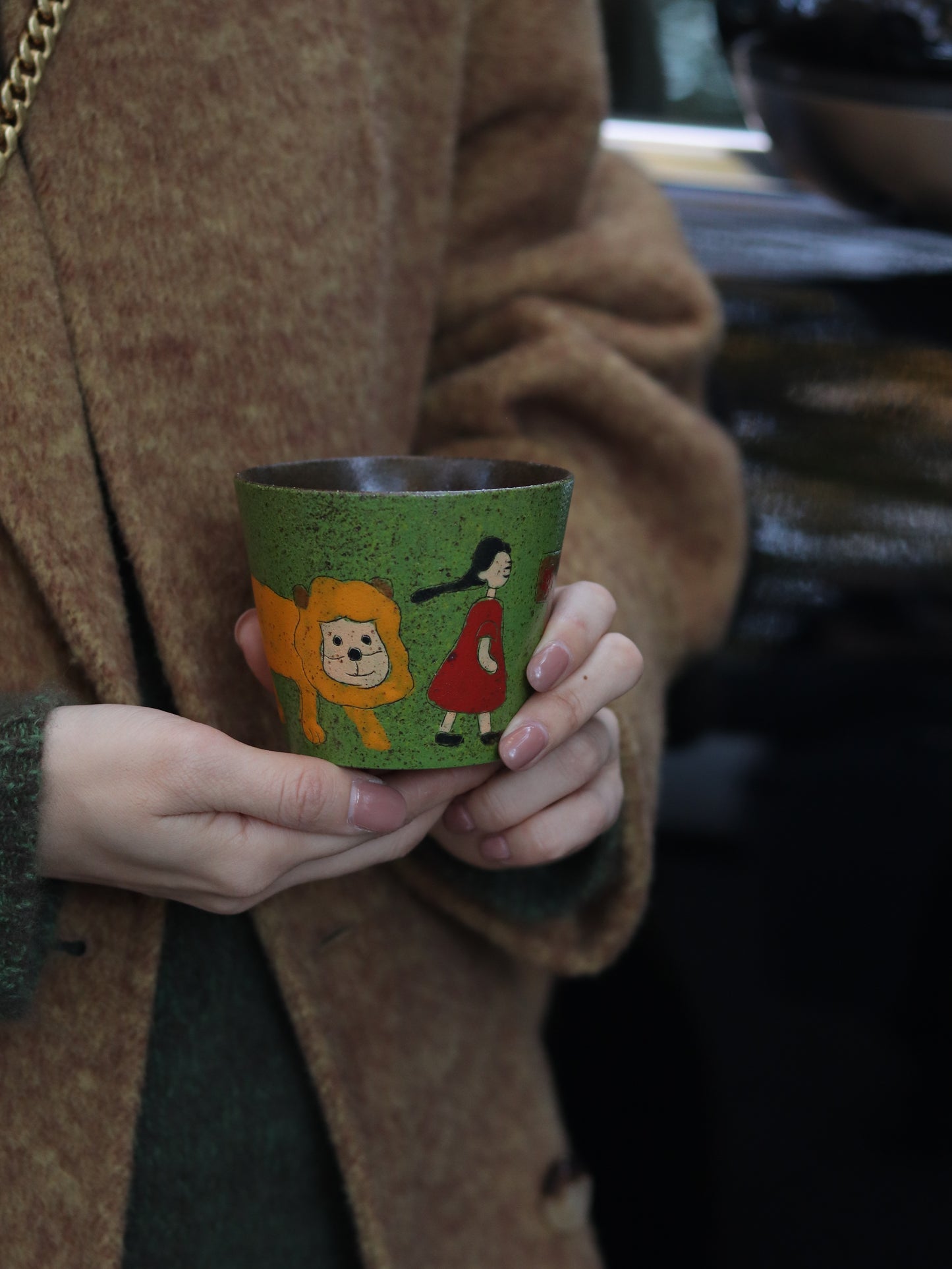 Lifestyle view of a woman holding the 270ml green ceramic cup