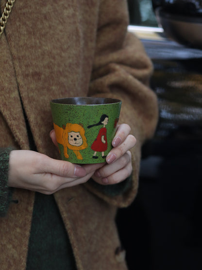 Lifestyle view of a woman holding the 270ml green ceramic cup