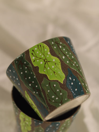 Close-up of stacked forest leaf cups showing the carved leaves and individually applied colour.
