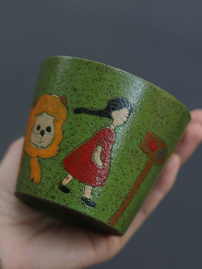 Close-up of the ceramic cup with carved girl and lion artwork